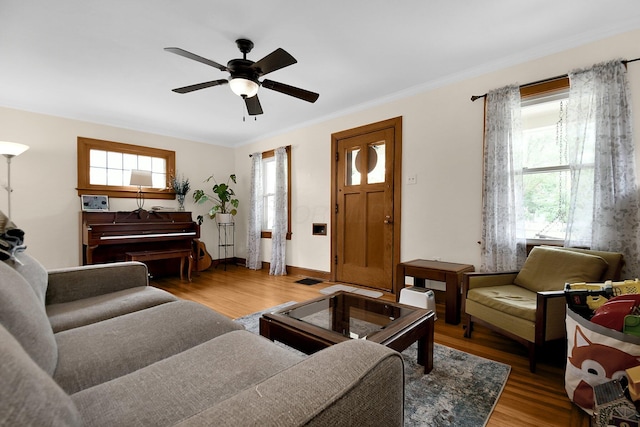 living room featuring ceiling fan, ornamental molding, and hardwood / wood-style flooring