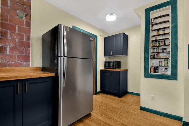 kitchen featuring light hardwood / wood-style flooring, stainless steel refrigerator, and butcher block countertops