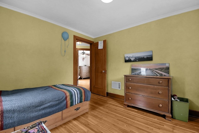 bedroom with light hardwood / wood-style flooring and crown molding