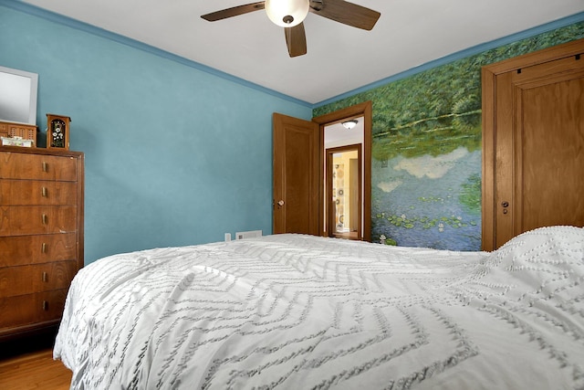 bedroom with ceiling fan, crown molding, and hardwood / wood-style flooring