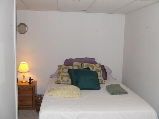 bedroom with a drop ceiling and carpet floors