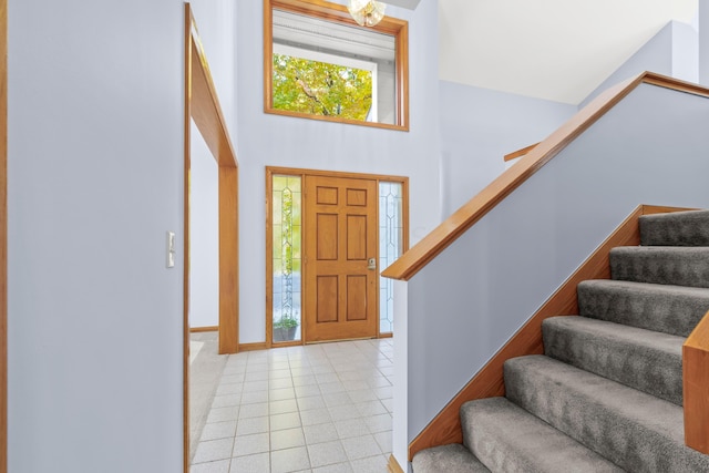 entryway featuring a towering ceiling and light tile patterned floors