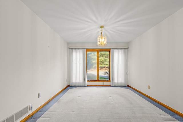 unfurnished room featuring a chandelier and light colored carpet