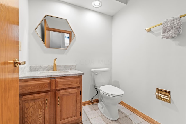 bathroom with tile patterned flooring, vanity, and toilet