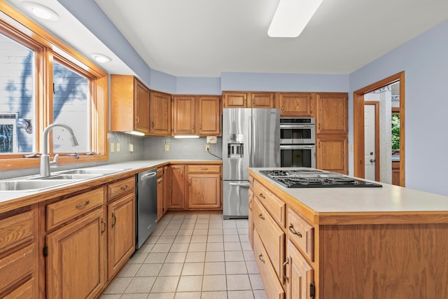 kitchen featuring appliances with stainless steel finishes, a kitchen island, a wealth of natural light, and sink