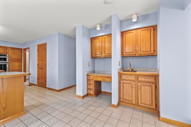 kitchen featuring double oven and light tile patterned flooring