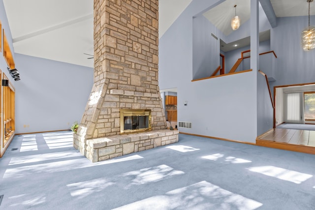 unfurnished living room with a stone fireplace, carpet floors, and high vaulted ceiling