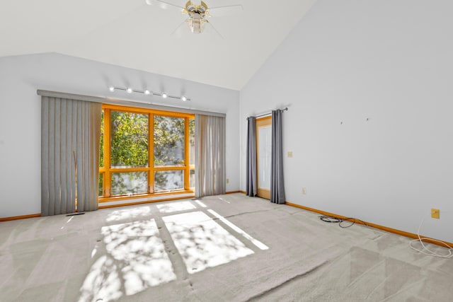 carpeted empty room with rail lighting, high vaulted ceiling, and ceiling fan