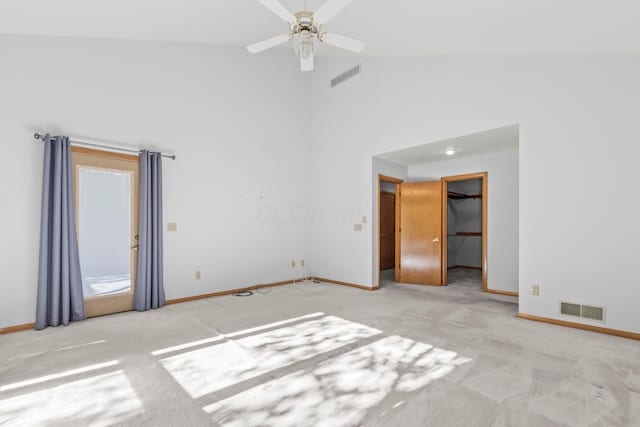 empty room with light colored carpet, high vaulted ceiling, and ceiling fan