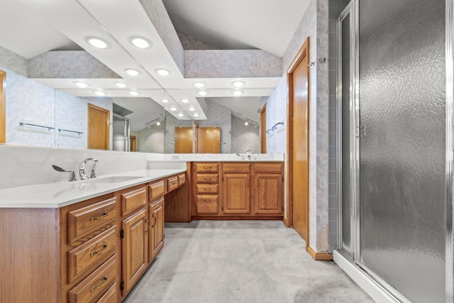 bathroom featuring vanity, a shower with door, and vaulted ceiling