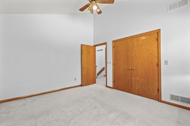 unfurnished bedroom with ceiling fan, high vaulted ceiling, and light colored carpet