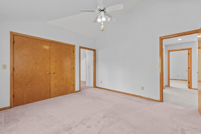 unfurnished bedroom with light carpet, a closet, ceiling fan, and lofted ceiling