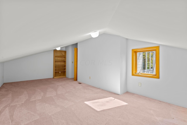 bonus room with light carpet and lofted ceiling