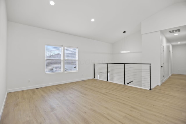 spare room featuring light hardwood / wood-style flooring and lofted ceiling