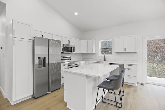 kitchen featuring a center island, light wood-type flooring, white cabinetry, and stainless steel appliances