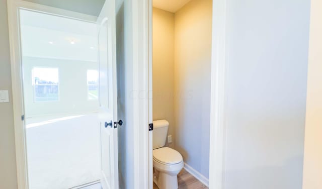 bathroom with hardwood / wood-style floors and toilet