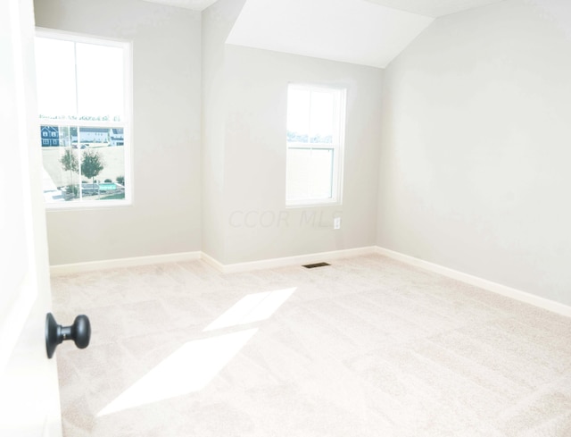 empty room with light carpet and lofted ceiling