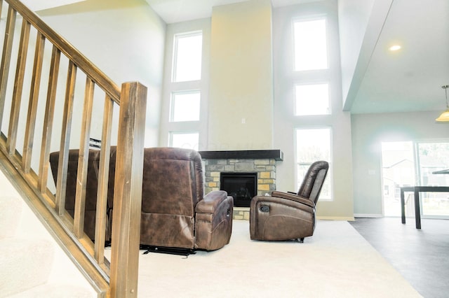 living area with a fireplace and a high ceiling