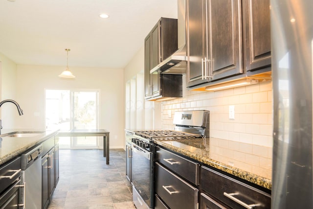 kitchen featuring sink, stainless steel appliances, light stone counters, pendant lighting, and dark brown cabinets