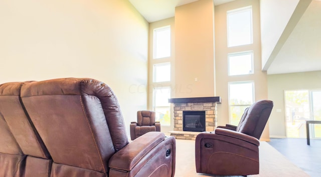 living room with a fireplace, a healthy amount of sunlight, and a high ceiling