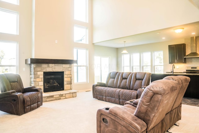 living room with a fireplace, sink, carpet, and a high ceiling