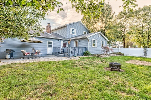 back of property featuring a patio, a yard, a deck, and an outdoor fire pit