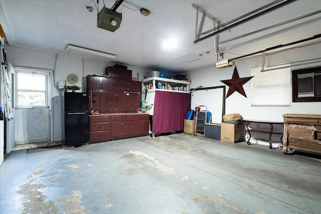 garage with a workshop area, black fridge, and a garage door opener