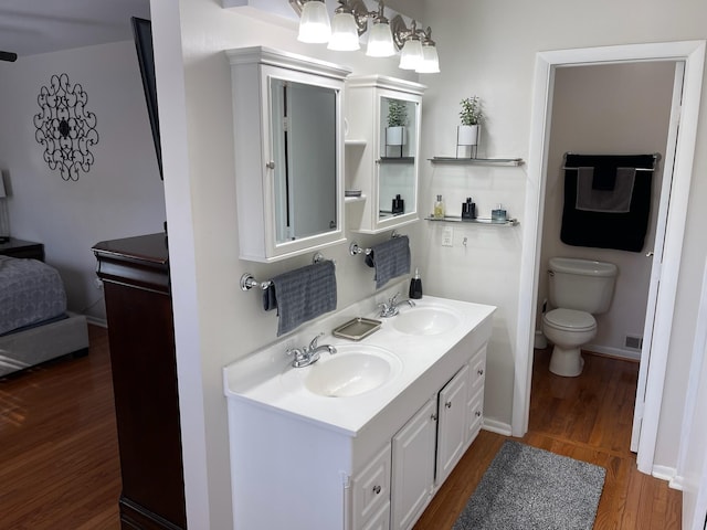 bathroom with hardwood / wood-style floors, vanity, and toilet