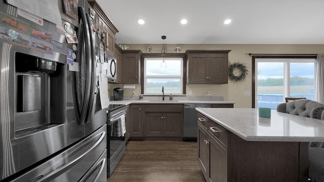 kitchen with pendant lighting, a wealth of natural light, sink, and stainless steel appliances