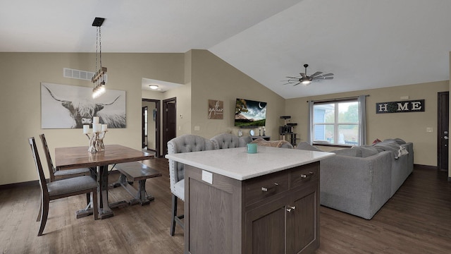 kitchen featuring dark hardwood / wood-style flooring, dark brown cabinets, vaulted ceiling, ceiling fan, and a kitchen island