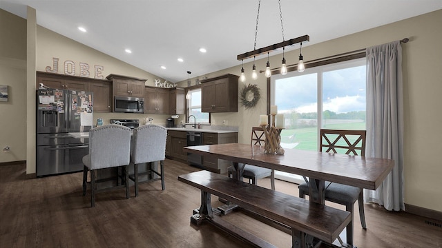 dining room featuring dark hardwood / wood-style flooring, vaulted ceiling, and sink