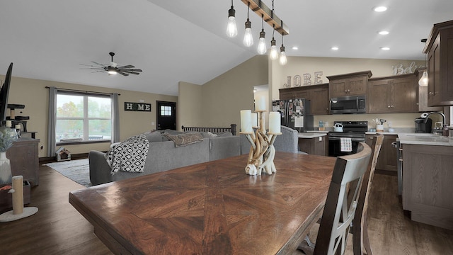 dining space with dark hardwood / wood-style floors, vaulted ceiling, ceiling fan, and sink