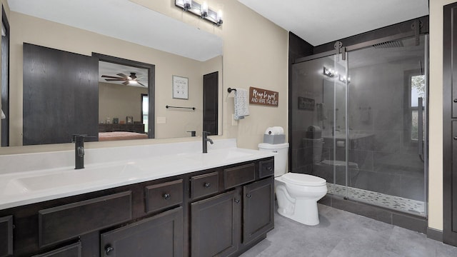 bathroom with ceiling fan, vanity, a shower with shower door, and toilet