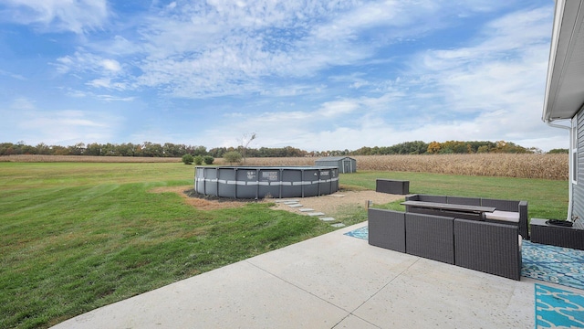 view of yard featuring an outdoor hangout area, a patio area, a covered pool, and a storage unit