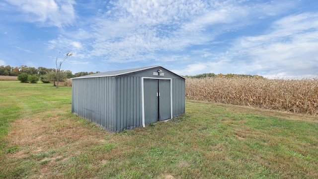 view of outbuilding featuring a lawn and a rural view