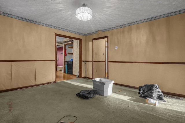 carpeted spare room featuring a textured ceiling