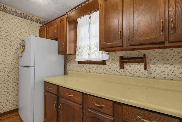 kitchen with white fridge and a textured ceiling