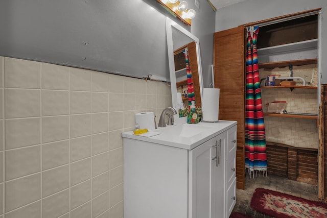 bathroom featuring vanity and tile walls