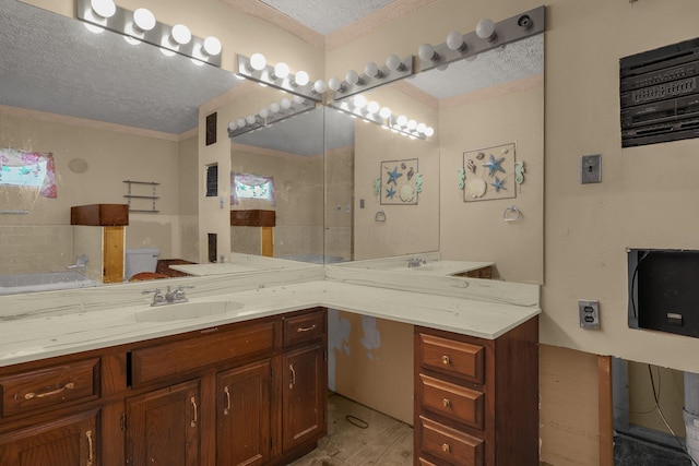 bathroom with vanity, wood-type flooring, a textured ceiling, and toilet