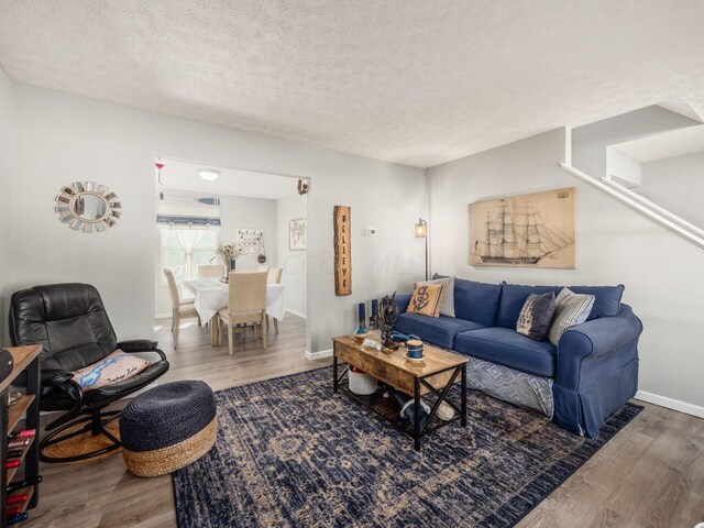 living room with wood-type flooring and a textured ceiling