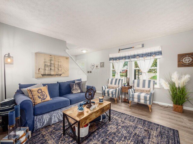 living room with wood-type flooring and a textured ceiling