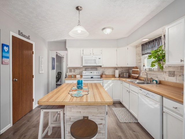 kitchen with pendant lighting, white cabinetry, white appliances, and sink