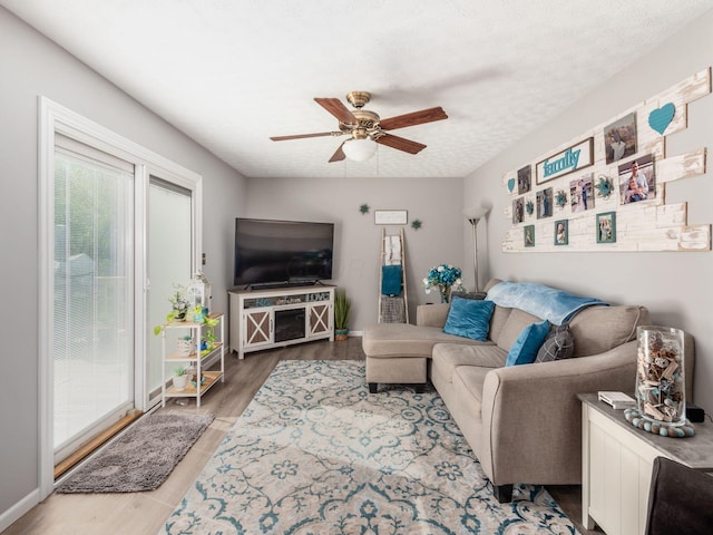 living room with a textured ceiling, hardwood / wood-style flooring, and ceiling fan