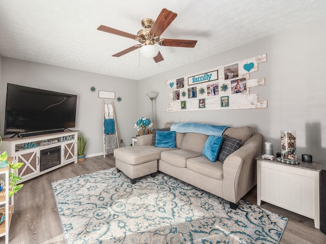 living room with wood-type flooring, a textured ceiling, and ceiling fan