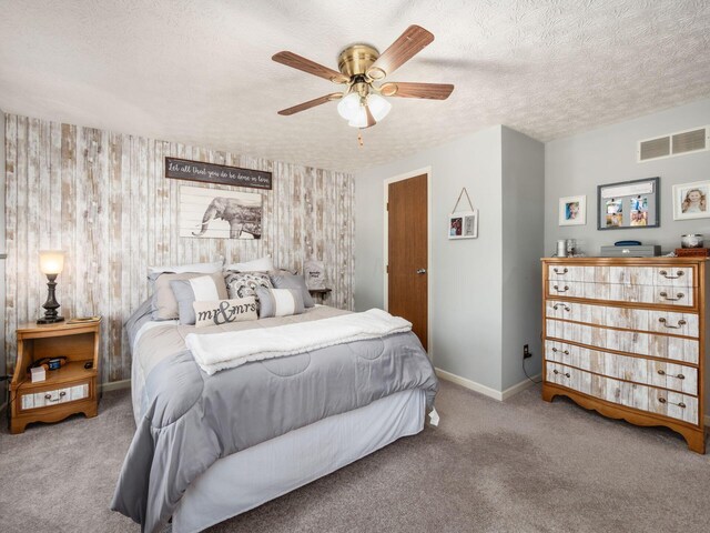 carpeted bedroom with ceiling fan and a textured ceiling