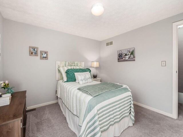 bedroom featuring carpet floors and a textured ceiling