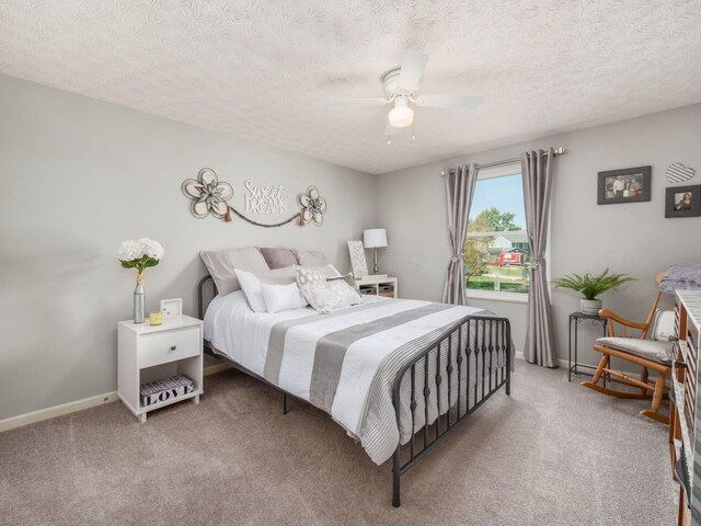 bedroom featuring ceiling fan, carpet floors, and a textured ceiling