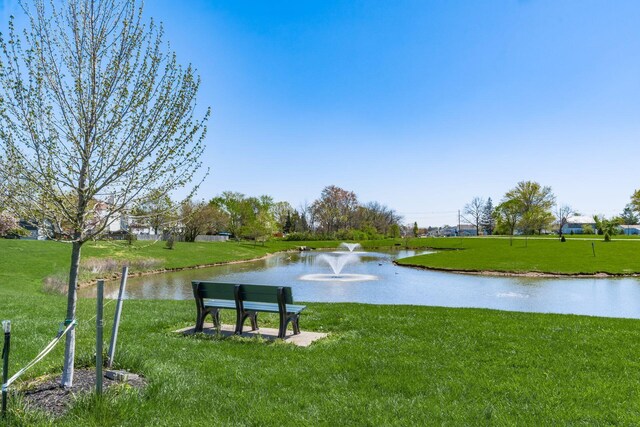 view of property's community with a yard and a water view