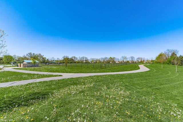 view of property's community featuring a lawn and a rural view