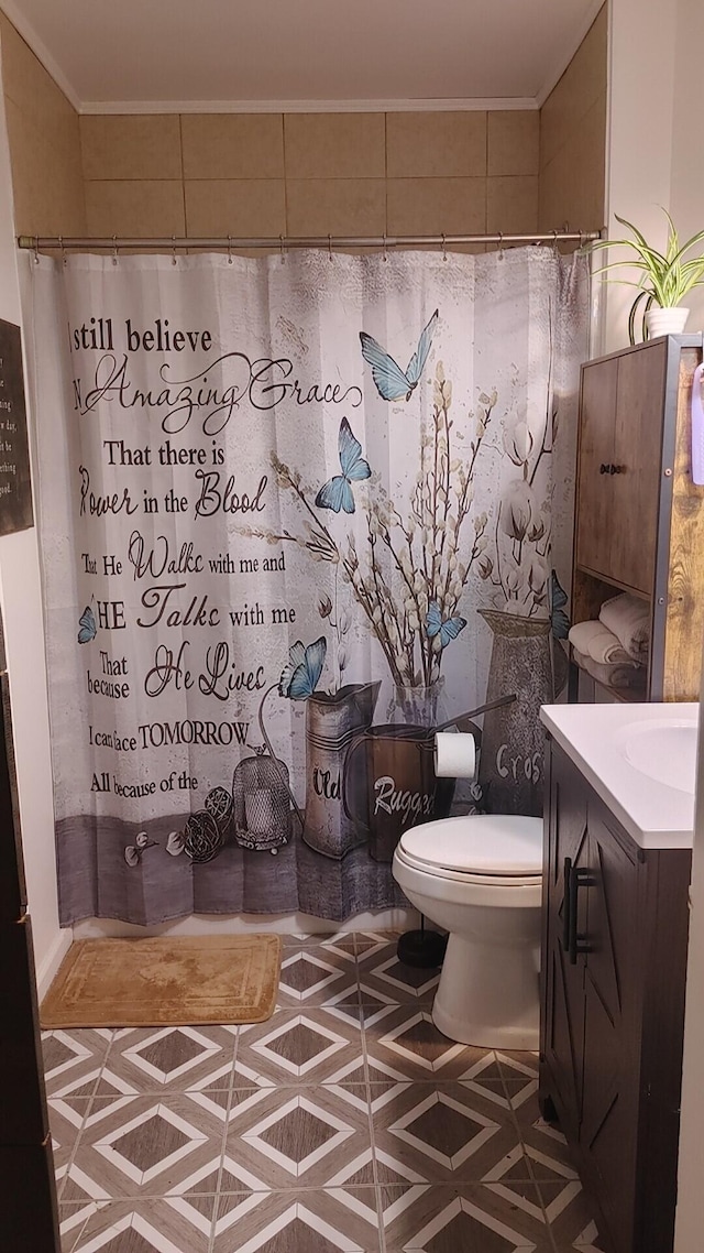 bathroom featuring vanity, toilet, and crown molding